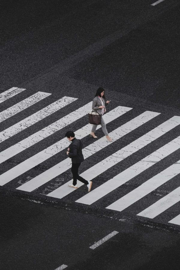 two people crossing a road from above