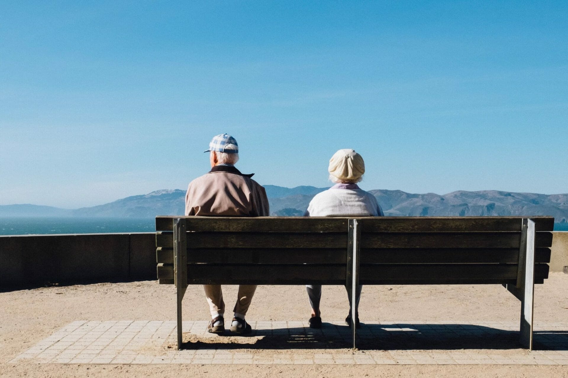 two pensioners on bench overlooking natural landscape